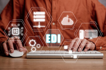 EDI-electronic data interchange concept, Person using computer on office desk with virtual screen EDI icon.