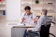 © Elnur - Old man in wheelchair visiting young male doctor