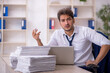 © Elnur - Young male employee and too much work in the office