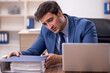 © Elnur - Young male employee and too much work in the office