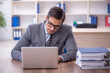 © Elnur - Young male employee unhappy with excessive work in the office