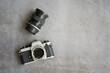 Vintage old camera and lens on cement floor background. Film camera retro style 1970s. Top view with copy space for any design.