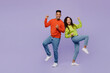 © ViDi Studio - Full body young couple two friends family man woman of African American ethnicity wear casual clothes together doing winner gesture celebrate clenching fists isolated on plain light purple background.