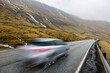 © Westend61 - Blurred car on road in front of mountain