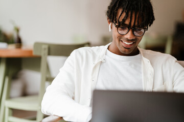 young african man working on laptop computer in cafe
