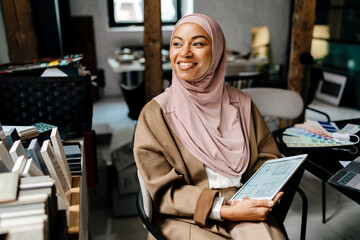 Wall Mural - Female muslim designer working on tablet computer at workshop