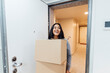 © Westend61 - Happy young woman holding boxes at home