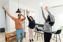 Happy Women And Man Dancing In Living Room At Home