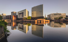 Germany, Hamburg, Office Buildings Reflecting In Elbe River At Dusk
