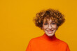 © Drobot Dean - Joyful middle-aged ginger woman looking at camera isolated over yellow background