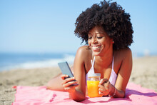 Happy Woman Using Smart Phone At Beach On Sunny Day