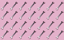 Pattern Of Rows Of Wrenches Flat Laid Against Pink Background