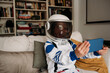 © Westend61 - Girl wearing space costume having video call on mobile phone at home
