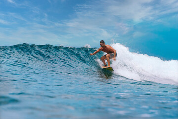 Shirtless male surfer on a wave at sunny day