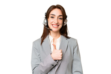 Wall Mural - Telemarketer caucasian woman working with a headset over isolated chroma key background giving a thumbs up gesture