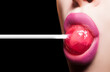 Lollipop in woman mouth. Girl lick lollipop, close up. Sexy seductive gesture.