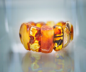 Wall Mural - Amber bracelet on a glass shelf.