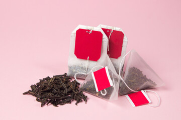 Wall Mural - Tea bags and loose tea on a pink background. Different types of tea