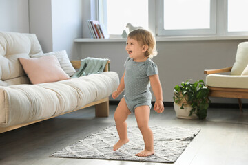 Wall Mural - Cute baby learning to walk in living room