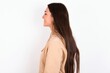 Profile portrait of nice Young caucasian woman wearing sweatshirt over white background look empty space toothy smile