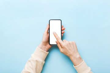 Top view of woman hands holding smart phone with blank copy space screen for your text message or information content. woman hand using phone white screen on top view