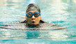 © Nassorn - Happy active senior woman has fun swimming in swimming pool. Portrait of Asian female elderly swimmer in swimwear enjoys water sport exercising. Older person leisure activity relaxing and healthy.