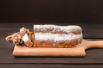 Wall Mural - Traditional Christmas cake Stollen on dark wooden background with copy space