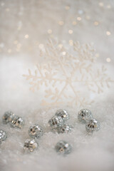 Canvas Print - Christmas snowflake and small mirror balls on a snow. Blurred background with beautiful bokeh. Shallow depth of field. Copy space. Airy atmosphere. Soft focus. 