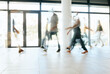 © S Fanti/peopleimages.com - Motion blur, busy office and business people walking, moving or fast speed in workplace, startup company or agency. Group of workers, crowd and employees rush movement in lobby, building and hallway