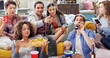 © Moose/peopleimages.com - Friends, drink and snacks and watching tv, relax and beer in living room, diversity and sports together in home. Men, women and people watch television, sports and streaming subscription with alcohol