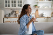 © DimaBerlin - Pleased smiling woman resting on sofa with cup of tea enjoying alone time at home, looking aside with dreamy face expression. Positive female starting day with morning coffee. Free time for parent