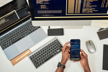 hands of software developer testing code of mobile application on smartphone