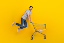 Full Length Photo Of Shiny Impressed Man Wear White T-shirt Jumping High Buying Supermarket Food Isolated Yellow Color Background