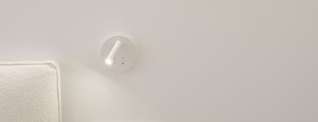 Bedside white LED wall lamp illuminating. Creative modern wall light source in bedroom. White European electrical socket outlet and switch. Electricity and illumination concept.