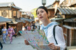 © PR Image Factory - lost asian Japanese female traveler consulting city map and looking into distance for directions at Ninenzaka and Sannenzaka in Kyoto japan with two girl tourist wearing kimono at background