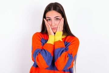 Young caucasian woman wearing colorful knitted sweater over white background Tired hands covering face, depression and sadness, upset and irritated for problem