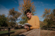 © ADDICTIVE STOCK - Man standing with book on wooden bridge