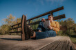 © ADDICTIVE STOCK - Happy man sitting on wooden bridge reading book