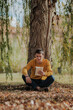 © ADDICTIVE STOCK - Happy man sitting under tree reading book
