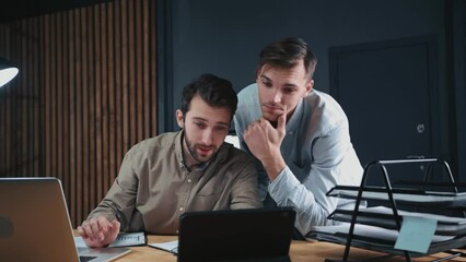 Canvas Print - two tired employees working with financial documents until late at night .