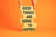 Good things happen symbol. Concept words Good things are going to happen on wooden blocks on a beautiful orange table orange background. Businessman hand. Business good things happen concept.