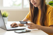© KMPZZZ - Internet banking, Online shopping at home, asian young woman hand in typing on keyboard, holding credit card, using laptop computer, spending money with purchase on store at home. Shopaholic ecommerce