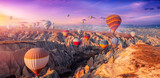 Aerial view amazing sunrise landscape in Cappadocia with colorful hot air balloon fly in sky over deep canyons, valleys. Concept banner travel Turkey