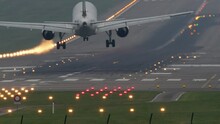 Long shot of a passenger airplane arriving to the airport in the evening