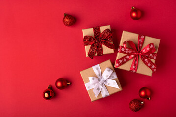 Wall Mural - Christmas gift boxes with red balls on red background.