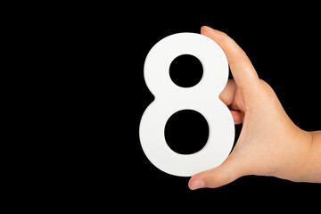 Aufkleber - Number eight in hand isolated on black background. Number 8 in a child's hand on a black background. To be inserted into a project or design.