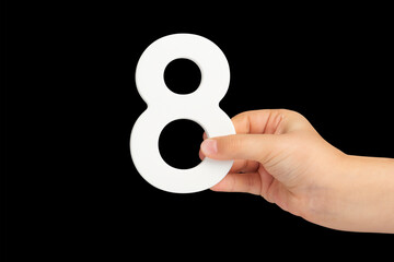 Aufkleber - Number eight in hand isolated on black background. Number 8 in a child's hand on a black background. To be inserted into a project or design.