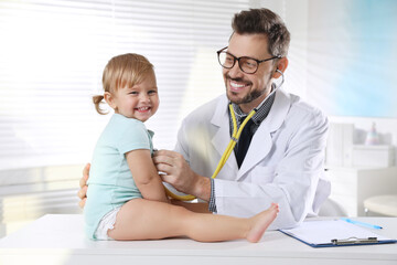 Wall Mural - Pediatrician examining baby with stethoscope in clinic