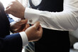 Man fastens the buttons on the groom's shirt. Preparation for the wedding
