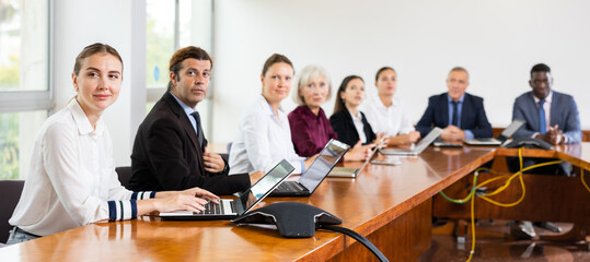 Group of diverse business people attending meeting in conference room, discussing work plan.